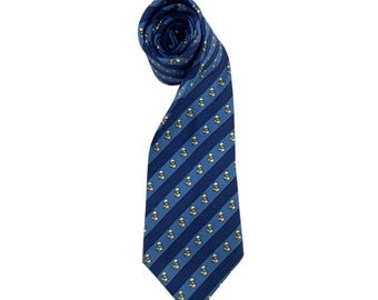 May include: A rolled-up blue tie with a striped pattern. The tie features alternating dark and light blue stripes, with small repeating white and yellow figures. The tie is made of a smooth fabric.