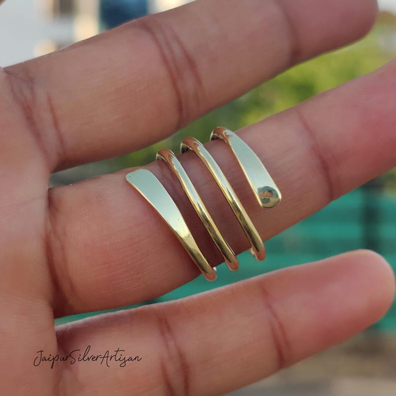 May include: A gold-toned spiral ring with multiple bands wrapped around the finger.