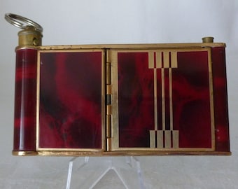 Estuche vintage musical estilo cámara Kamra con forma de cuña para compacto y lápiz labial, fabricado en Alemania.