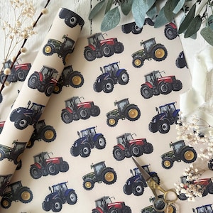 May include: Wrapping paper with a repeating pattern of tractors in various colours, including red, blue, green, and black, with yellow wheels. The background is tan. The image is decorated with sprigs of white flowers and greenery.