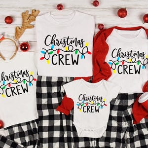 May include: Family matching Christmas pajamas.  Adult and child sizes feature white shirts with black text reading 'Christmas Crew' and colorful string lights.  Black and white plaid pajama pants are also included. Baby size features a white bodysuit with the same design.  Red cardigan included for adult size.