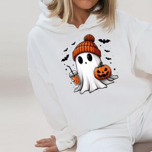 Pu&ograve; includere: Felpa con cappuccio bianca con un fantasma dei cartoni animati che indossa un berretto arancione e tiene in mano una zucca e una bevanda. Pipistrelli e stelle nere circondano il fantasma, creando un tema di Halloween.