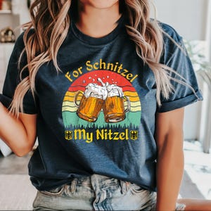 K&ouml;nnte beinhalten: Ein marineblaues T-Shirt mit einer Grafik im Vintage-Stil von zwei Bierkr&uuml;gen und dem Text "For Schnitzel My Nitzel".
