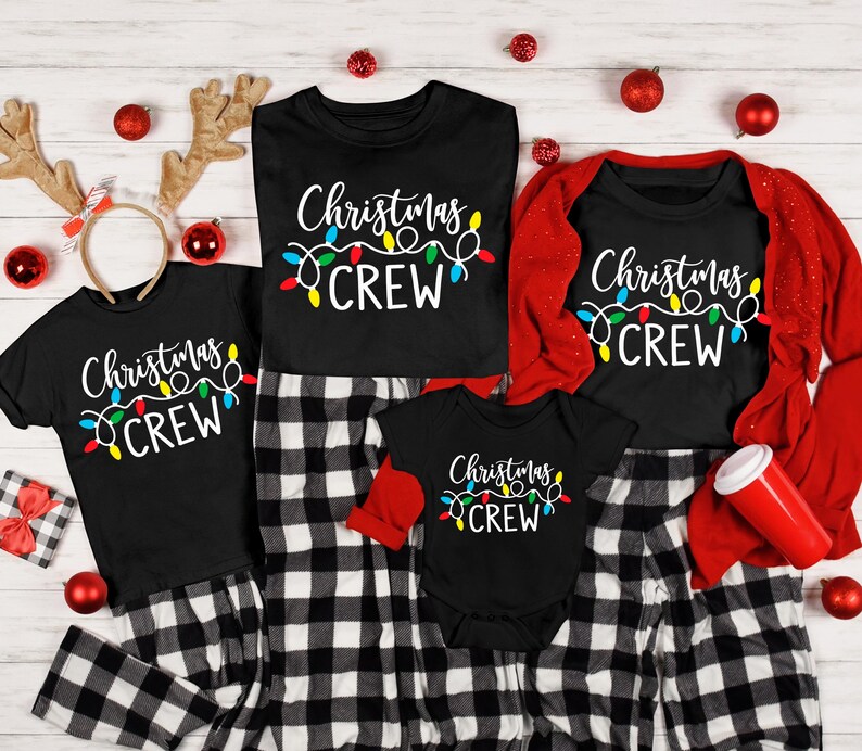 Puede incluir: Camisetas negras de Christmas Crew y un body para beb&eacute; con dise&ntilde;o de luces de colores. Las camisetas se combinan con pantalones de pijama a cuadros blancos y negros. Adornos navide&ntilde;os rojos y cuernos de reno completan el tema festivo.