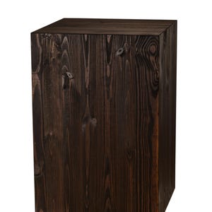 May include: A dark brown wooden cube with a smooth, polished surface. The cube is made of solid wood and has a natural grain pattern.