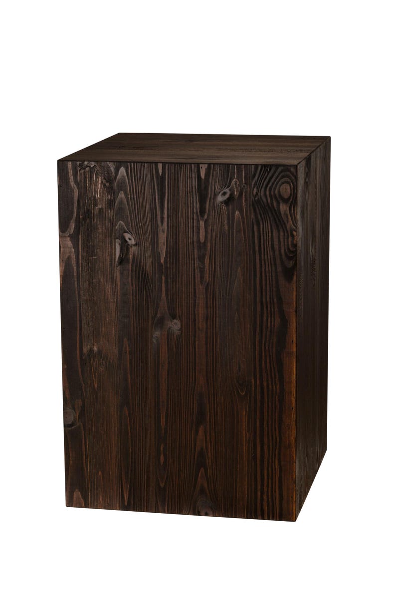 May include: A dark brown wooden cube with a smooth, polished surface. The cube is made of solid wood and has a natural grain pattern.