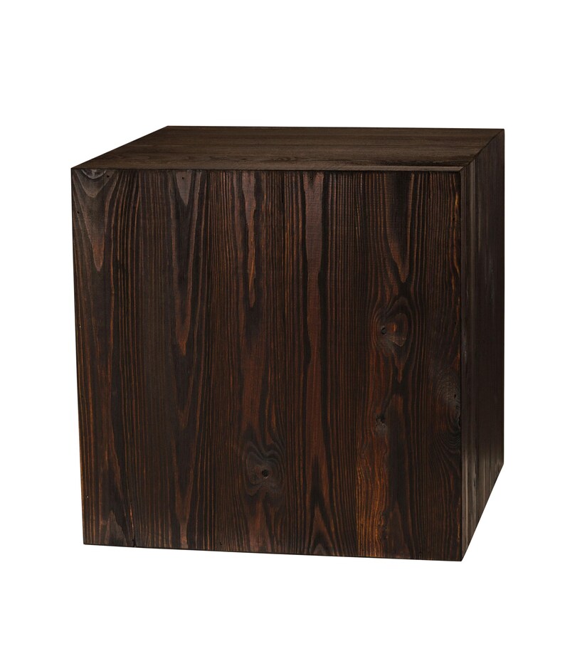 May include: A dark brown wooden cube with a smooth, textured surface. The cube is made of solid wood and has a natural, rustic look.