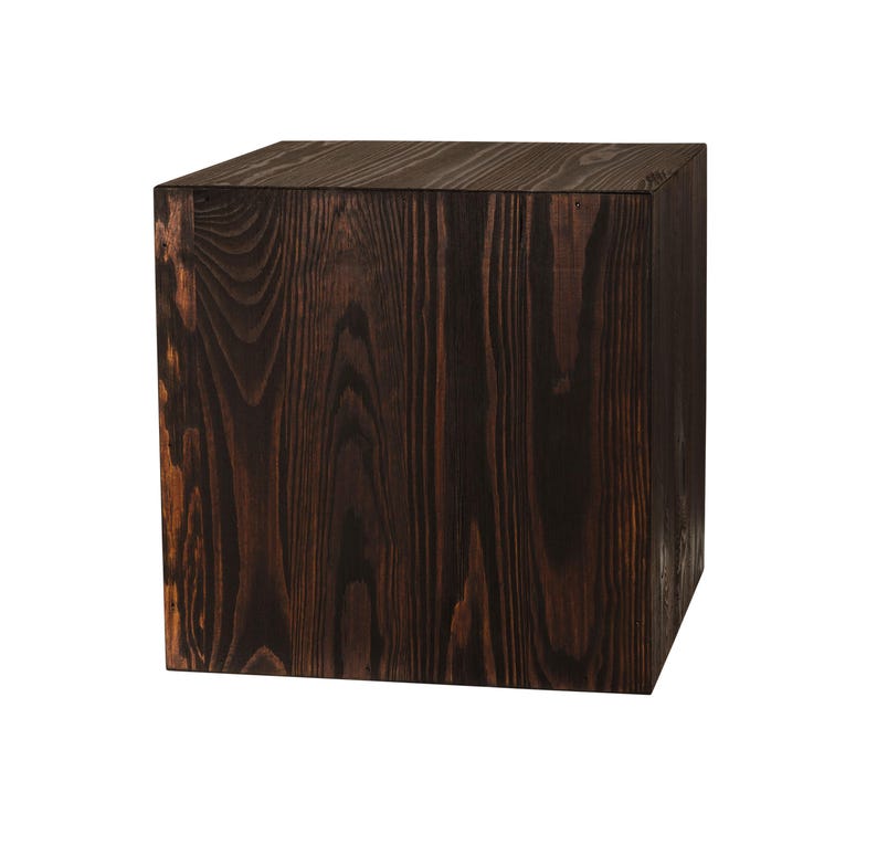 May include: A dark brown wooden cube, perfect for displaying items or as a decorative accent.