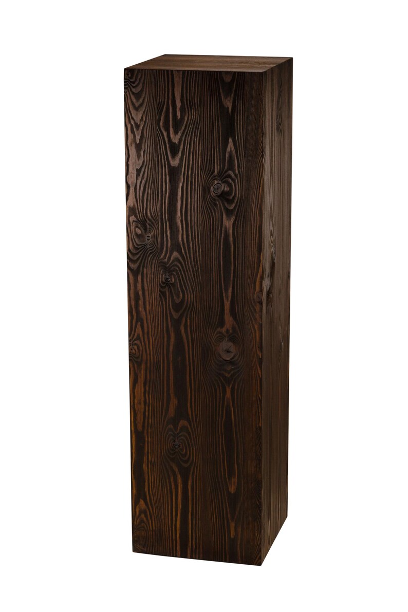 May include: A dark brown wooden pedestal with a rectangular shape and a natural wood grain pattern.