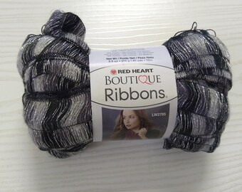 May include: A skein of black and silver metallic yarn called Red Heart Boutique Ribbons. The label says "Net Wt/Poids Net/Peso Neto 3.5 oz / 100 g / 142 yds / 130 m" and "LW2785".