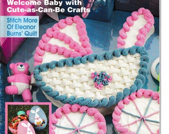 May include: Cover of "Crafting Traditions" magazine, featuring a baby carriage cake with pink and blue frosting. The cover also shows decorated cakes and a pink teddy bear. Text includes "Welcome Baby" and "Full-Size Patterns."
