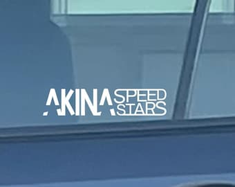 Può includere: Un'auto blu con un adesivo bianco "AKINA SPEED STARS" sul lunotto posteriore. L'auto ha un portapacchi nero sul tetto e una maniglia della porta nera.