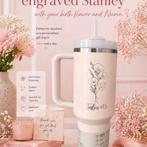 May include: A 40 oz engraved Stanley tumbler in cream with a floral design and the name "Talia #13". The tumbler has a handle and a straw. The text on the tumbler says "with your birth flower and Name."