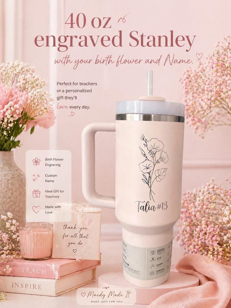 May include: A 40 oz engraved Stanley tumbler in cream with a floral design and the name "Talia #13". The tumbler has a handle and a straw. The text on the tumbler says "with your birth flower and Name."