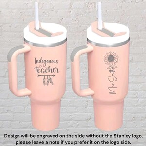 May include: Two pink insulated tumblers with handles and white lids. One tumbler has the text "Indegenous teacher" with feather accents. The other has a sunflower and the name "Mrs. Smith". Each tumbler has a white straw.