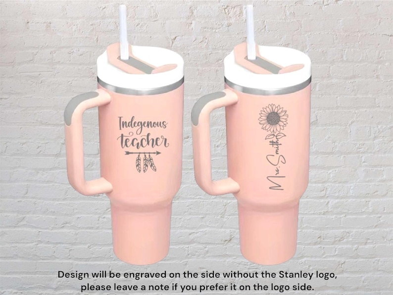 May include: Two pink insulated tumblers with handles and white lids. One tumbler has the text "Indegenous teacher" with feather accents. The other has a sunflower and the name "Mrs. Smith". Each tumbler has a white straw.