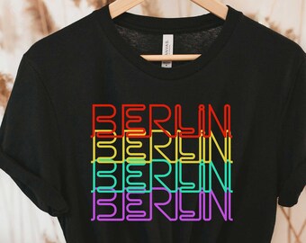 May include: Black t-shirt with the word "BERLIN" repeated four times in a rainbow pattern.