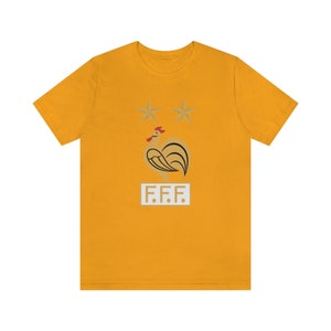 May include: A yellow t-shirt with a gold rooster and two stars above it. The text "F.F.F." is below the rooster.