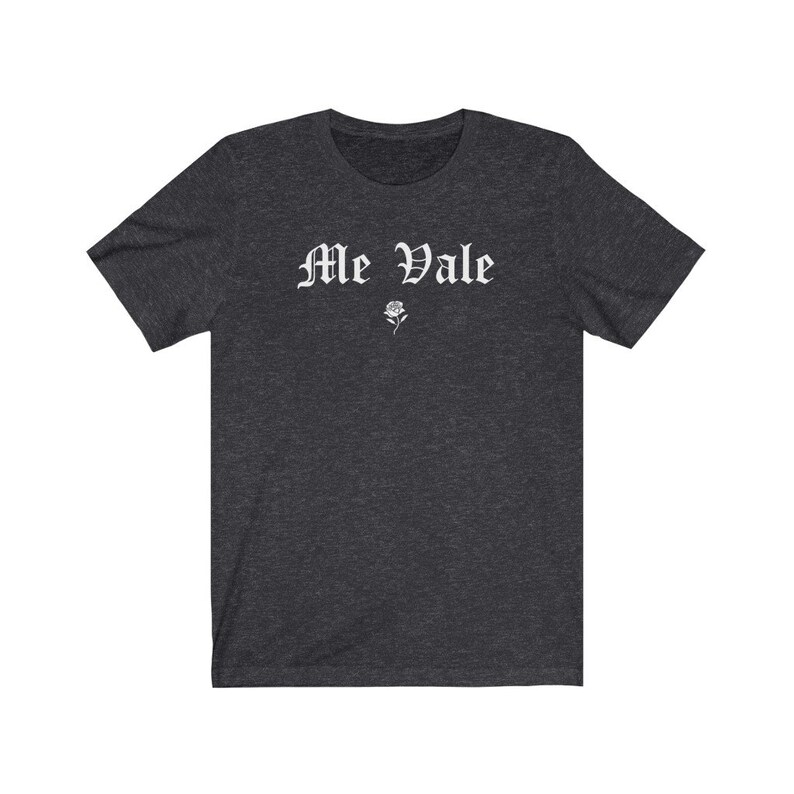 May include: A dark heather grey t-shirt with the text "Me Vale" in white gothic lettering and a small white rose graphic.