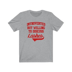 May include: Gray t-shirt with red text that reads "Introverted but willing to discuss Lashes".