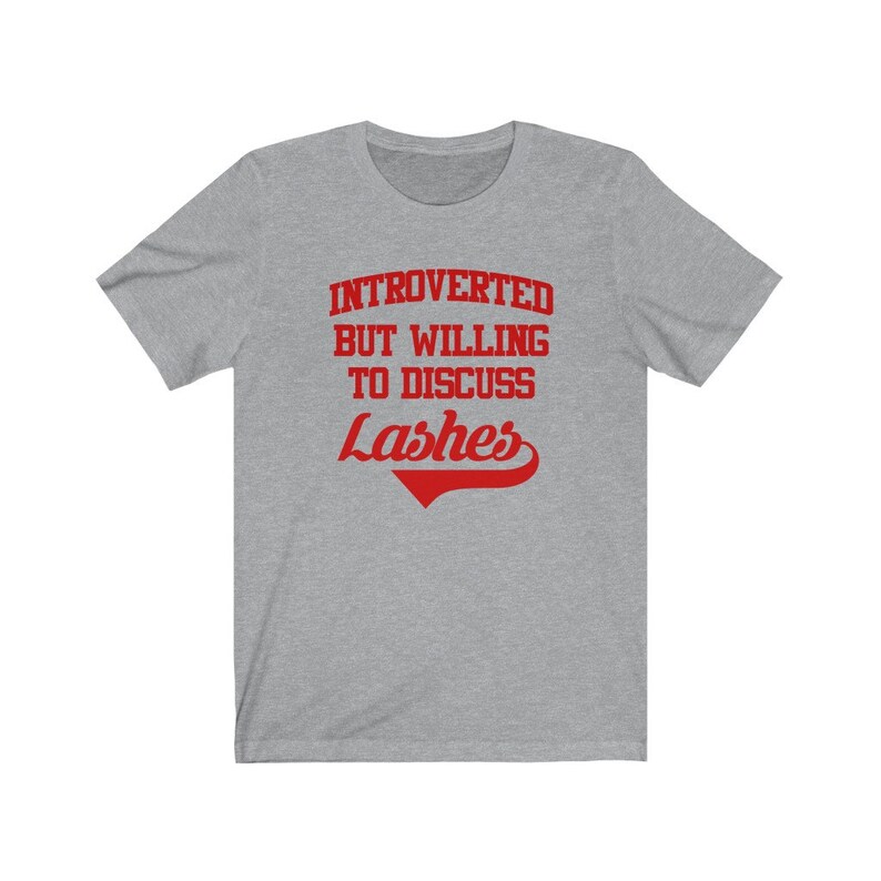 May include: Gray t-shirt with red text that reads "Introverted but willing to discuss Lashes".