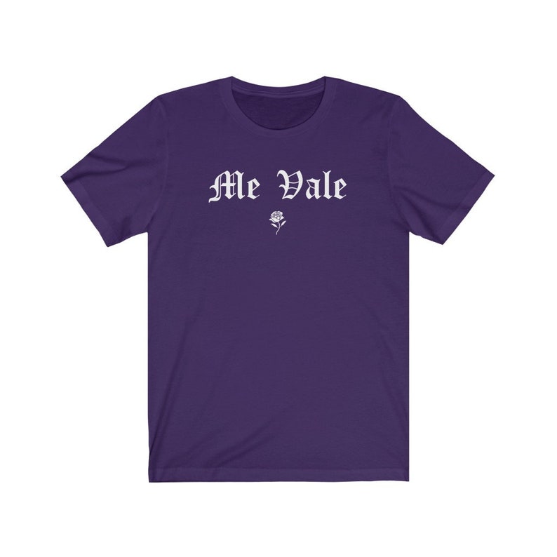 May include: Purple short-sleeved t-shirt with the text "Me Vale" in white gothic lettering and a small white rose graphic.