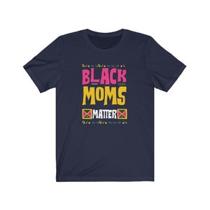 May include: Navy blue t-shirt with the text "Black Moms Matter" in pink, yellow, and green. The text is surrounded by a colorful geometric pattern.