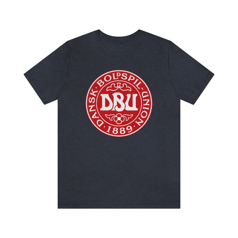 Puede incluir: Una camiseta azul marino con un logotipo circular rojo. El logotipo dice "Dansk Boldspil-Union DBU 1889" en texto blanco.