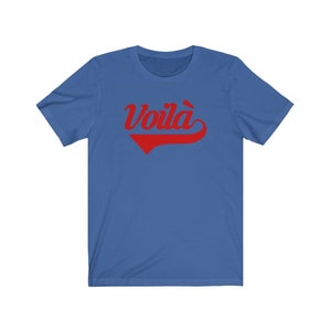 Puede incluir: Una camiseta azul real con un gr&aacute;fico rojo de estilo vintage que dice "&iexcl;Voil&agrave;!"