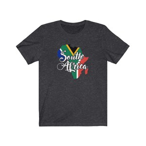 May include: A dark heather grey t-shirt with a graphic of the South African flag in the shape of the continent of Africa. The text "South Africa" is written in white cursive lettering.