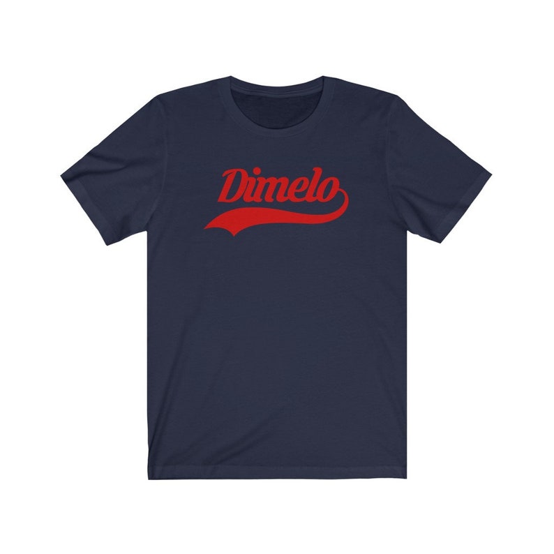 May include: A navy blue t-shirt with a red "Dimelo" graphic in a vintage baseball style font.