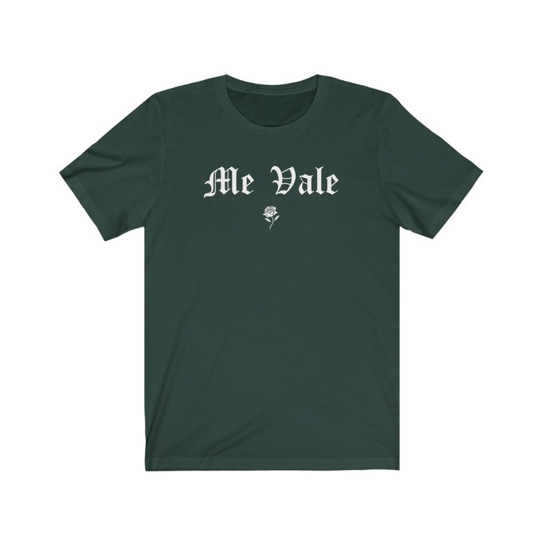 May include: A dark green t-shirt with the text "Me Vale" in white gothic lettering and a small white rose graphic.