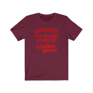 May include: Burgundy t-shirt with red text that reads "Introverted but willing to discuss Lashes".