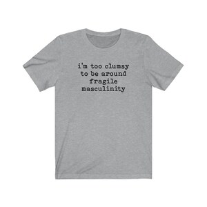 Puede incluir: Una camiseta gris jaspeada con el texto "i'm too clumsy to be around fragile masculinity" impreso en negro.