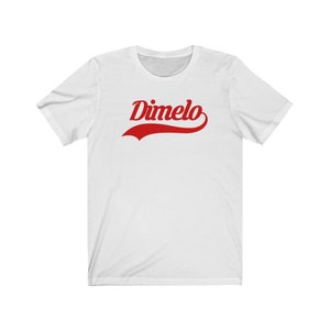 May include: White t-shirt with a red "Dimelo" graphic in a vintage baseball font.