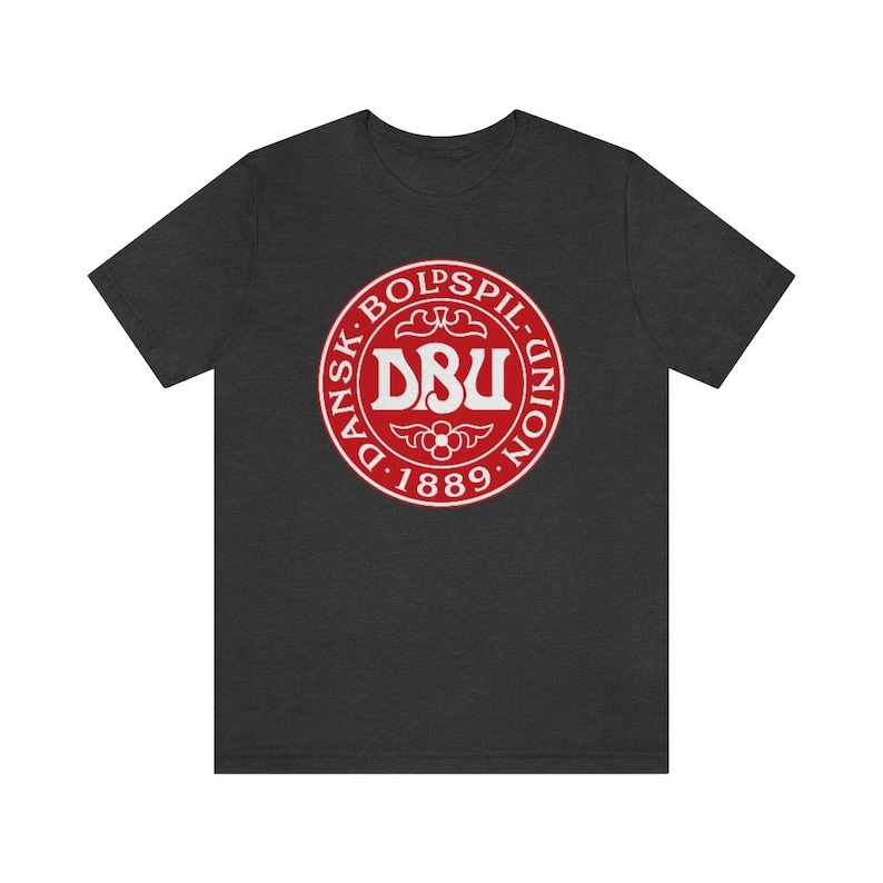 Puede incluir: Una camiseta gris oscuro jaspeada con un logotipo circular rojo que muestra el texto "Dansk Boldspil-Union DBU 1889".