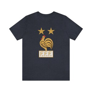 May include: A navy blue t-shirt with a gold rooster and two stars above it. The text "F.F.F." is below the rooster.