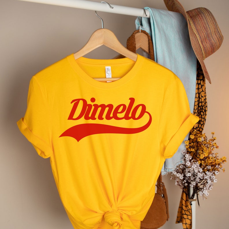 May include: Yellow t-shirt with a red "Dimelo" graphic in a retro font style.