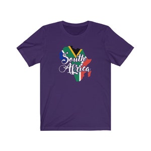 May include: Purple short-sleeved t-shirt with a graphic of the South African flag in the shape of the country's outline. The text "South Africa" is written in white cursive lettering.