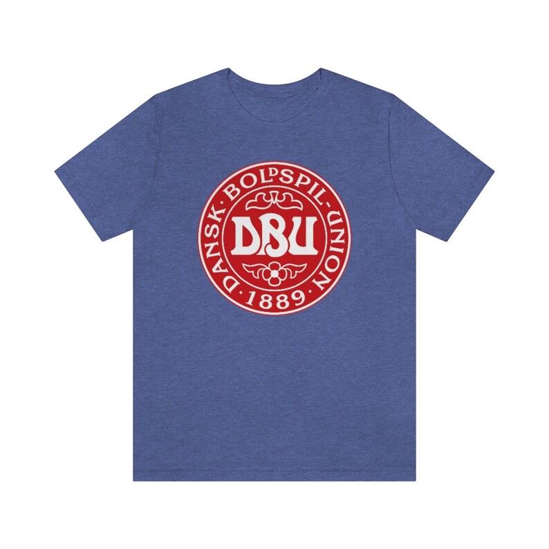 Puede incluir: Una camiseta azul con un logotipo circular rojo. El logotipo dice "Dansk Boldspil-Union DBU 1889".