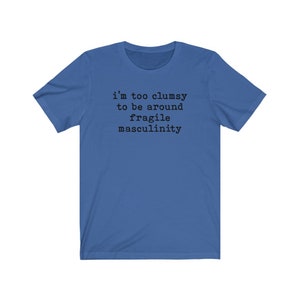 Puede incluir: Una camiseta azul real con el texto "i'm too clumsy to be around fragile masculinity" impreso en negro.