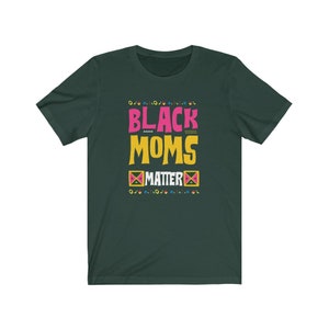 May include: A dark green t-shirt with the text "Black Moms Matter" in pink, yellow, and black lettering. The text is surrounded by a colorful geometric pattern.