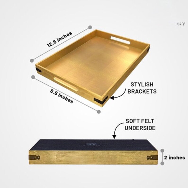 May include: Gold serving tray with black metal brackets and a soft felt underside. The tray measures 12.5 inches by 8.5 inches and is 2 inches tall.