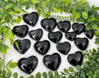 May include: A collection of black obsidian heart-shaped stones. The stones are polished and have a smooth, glossy finish.
