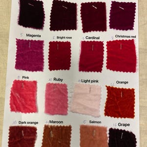 May include: A color chart featuring sixteen fabric swatches in various shades of red, pink, and orange. Each swatch is labeled with a color name, including "Bordeaux," "Dark red," "Rose," "Fuchsia," "Magenta," "Bright rose," "Cardinal," "Christmas red," "Pink," "Ruby," "Light pink," "Orange," "Dark orange," "Maroon," "Salmon," and "Grape."