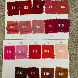 May include: A colour swatch chart displaying twenty fabric samples in shades of red, pink, and brown. Each sample is labelled with a number from S1 to S20. The samples are arranged on white paper.