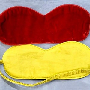May include: Two sleep masks, one red velvet and one yellow silk.