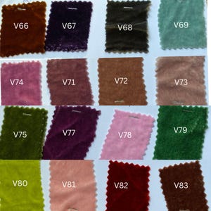 May include: A selection of velvet fabric swatches in a range of colours, such as brown, purple, green, pink, and teal. Each swatch is labelled with a white tag, displaying the different colour options.