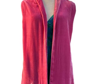 May include: A vibrant pink velvet shawl draped over a mannequin. The shawl is embroidered with the name "Anna" in a delicate script. The garment is displayed over a green and blue patterned dress.