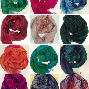 Könnte beinhalten: Sortiment von 12 Seidenschals in verschiedenen Farben und Mustern. Die Schals sind gefaltet und in einem Raster angeordnet.